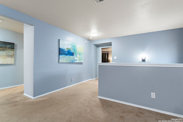 unfurnished room with a textured ceiling and carpet floors