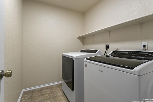 clothes washing area featuring laundry area, baseboards, and separate washer and dryer