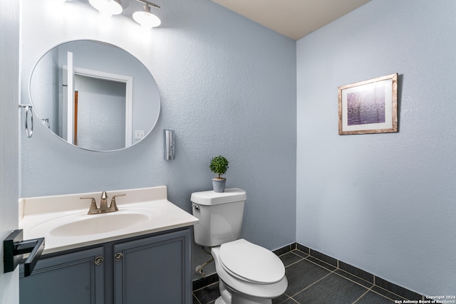 bathroom featuring tile patterned flooring, toilet, and vanity