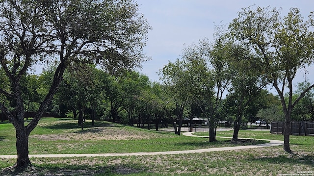 view of property's community with a yard and fence