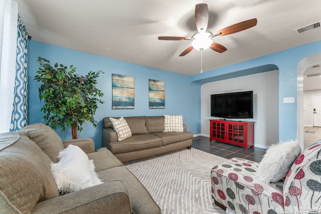 tiled living room featuring a textured ceiling and ceiling fan