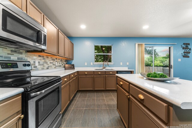 kitchen featuring sink, appliances with stainless steel finishes, and decorative backsplash