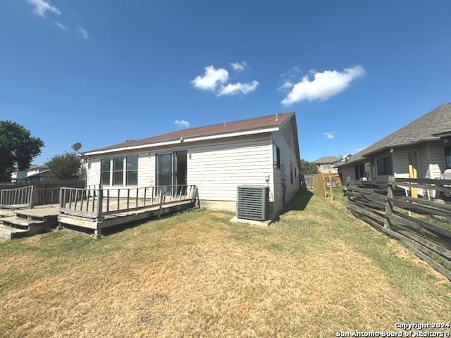 back of house featuring a deck, fence, central AC unit, and a lawn