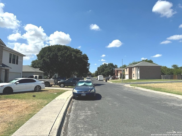 view of street with a residential view, curbs, and sidewalks