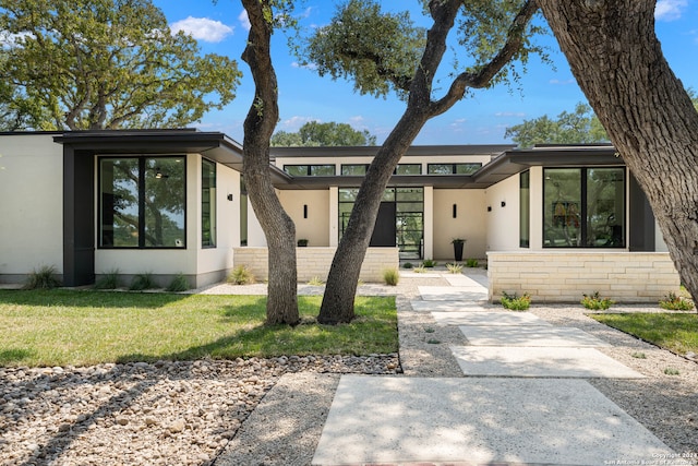 contemporary home with a front lawn