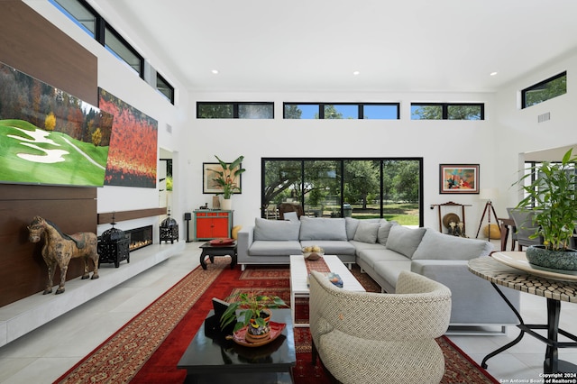 living room featuring a towering ceiling and tile patterned floors