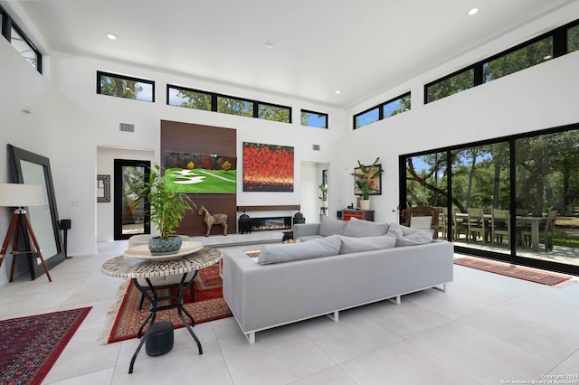 living room with a high ceiling and light tile patterned floors