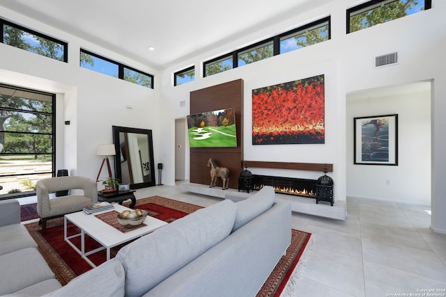 tiled living room with plenty of natural light and a towering ceiling