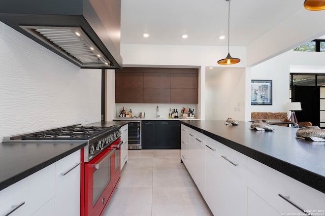 kitchen featuring beverage cooler, high end range, premium range hood, and white cabinets