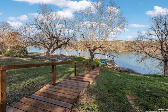 dock area with a water view and a lawn