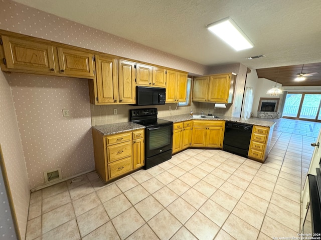 kitchen with black appliances, sink, kitchen peninsula, and a textured ceiling