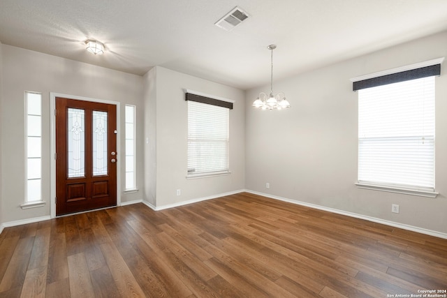 entryway with a notable chandelier and wood-type flooring