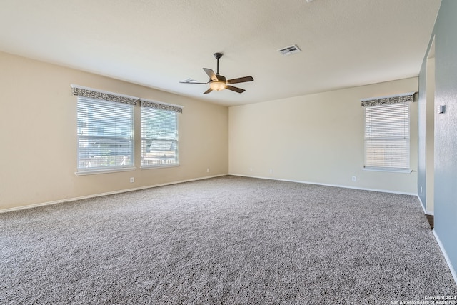 empty room featuring carpet flooring, ceiling fan, and a textured ceiling