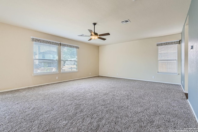 empty room with baseboards, carpet, visible vents, and a ceiling fan