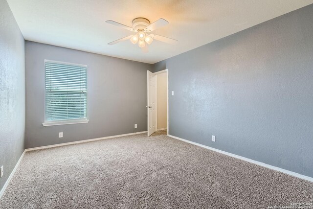 carpeted spare room featuring a textured ceiling and ceiling fan