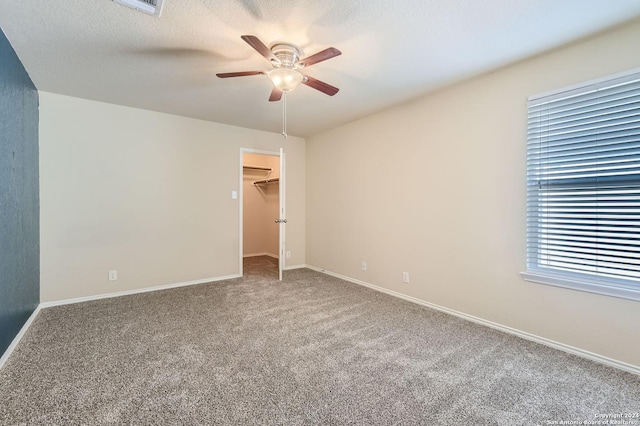 spare room with ceiling fan, a textured ceiling, baseboards, and carpet flooring