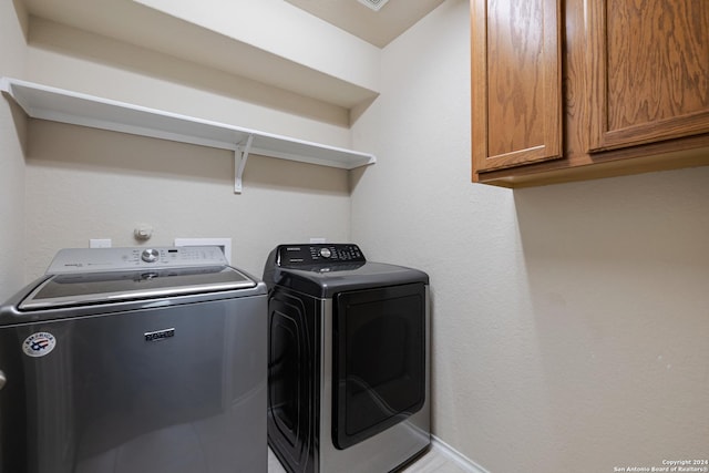 washroom with cabinet space and independent washer and dryer