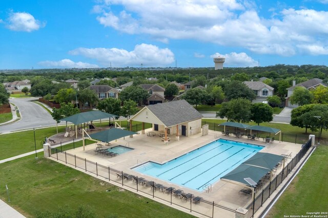 view of swimming pool featuring a playground, a lawn, and a patio