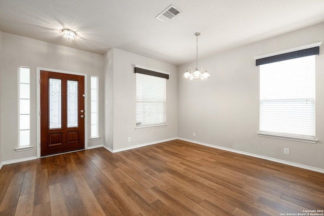 entryway featuring baseboards, hardwood / wood-style floors, visible vents, and a healthy amount of sunlight