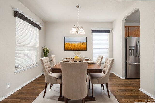 dining area featuring plenty of natural light, dark hardwood / wood-style flooring, and a notable chandelier