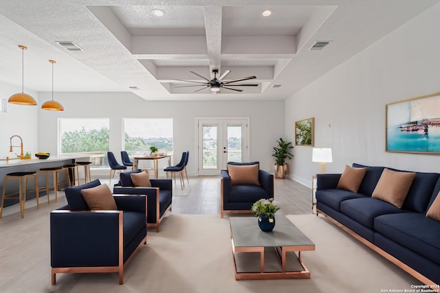 living room featuring coffered ceiling, ceiling fan, light tile patterned flooring, and a textured ceiling