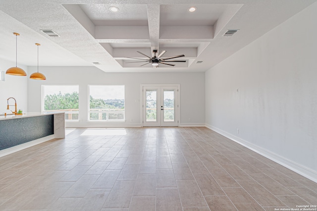 empty room featuring coffered ceiling, ceiling fan, sink, and a textured ceiling