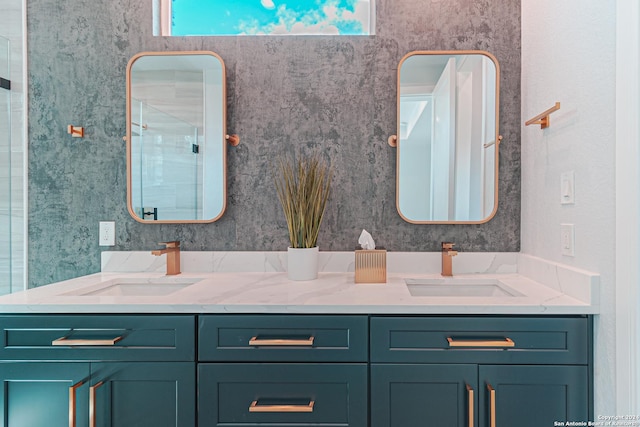 bathroom with double vanity, a stall shower, and a sink