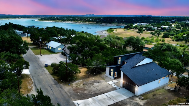 aerial view at dusk featuring a water view