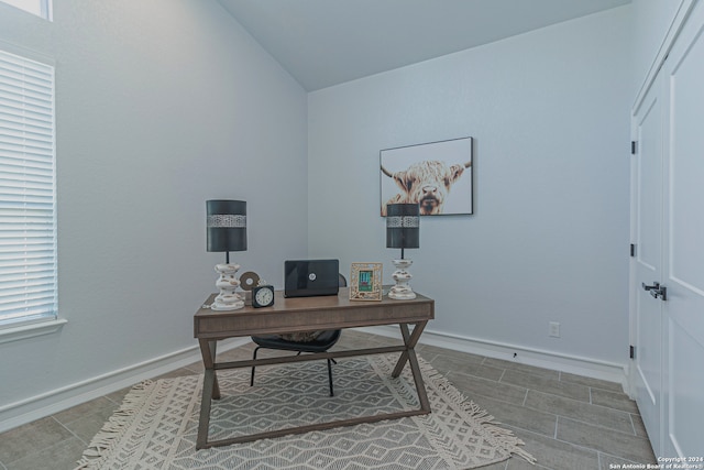 home office with lofted ceiling and baseboards