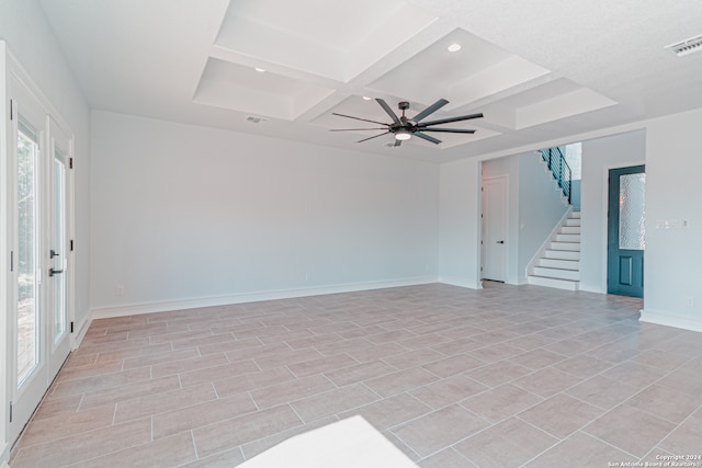 empty room with plenty of natural light, ceiling fan, coffered ceiling, and beam ceiling