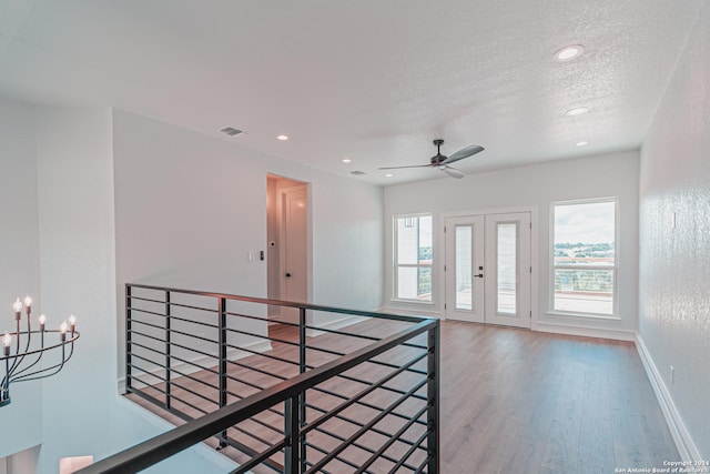 unfurnished room featuring a textured ceiling, recessed lighting, wood finished floors, visible vents, and baseboards