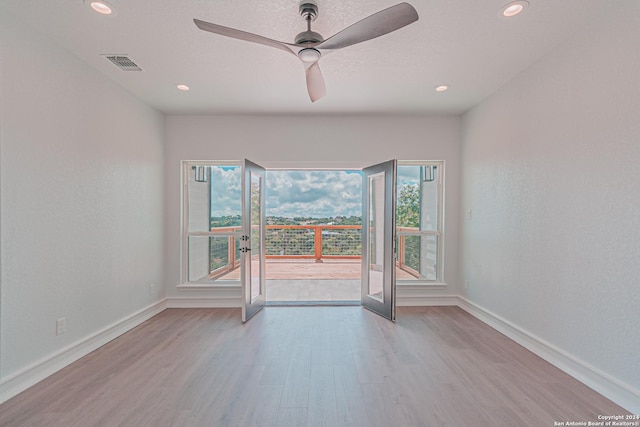 unfurnished room featuring wood finished floors, visible vents, and baseboards