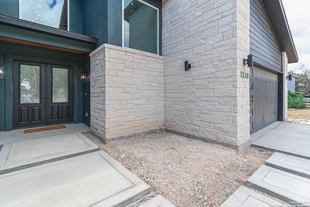 doorway to property featuring a garage and french doors