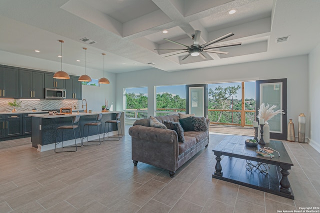 living room with plenty of natural light, coffered ceiling, visible vents, and a ceiling fan