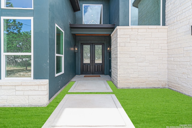 doorway to property featuring a lawn