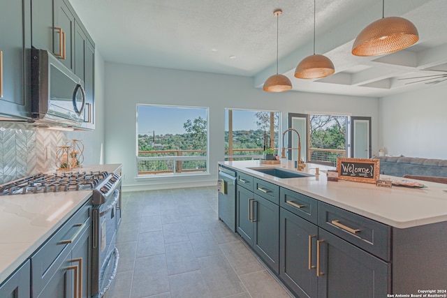 kitchen featuring tasteful backsplash, baseboards, decorative light fixtures, stainless steel appliances, and a sink