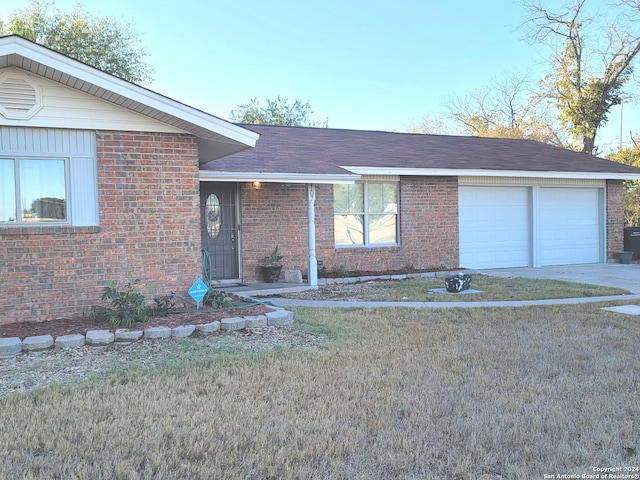 view of front of property with brick siding, a shingled roof, a front yard, a garage, and driveway