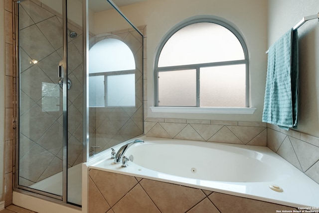 bathroom featuring a healthy amount of sunlight and separate shower and tub