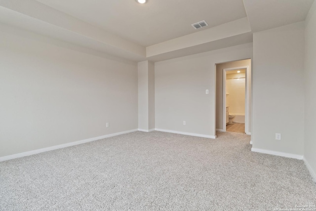 carpeted spare room with visible vents and baseboards