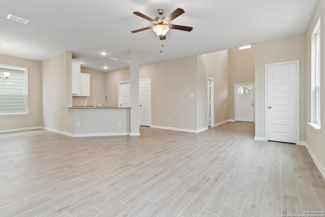 unfurnished living room featuring wood-type flooring and ceiling fan