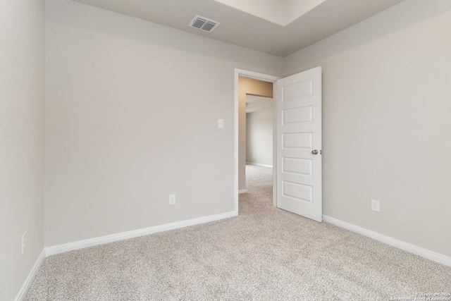 carpeted empty room featuring visible vents and baseboards