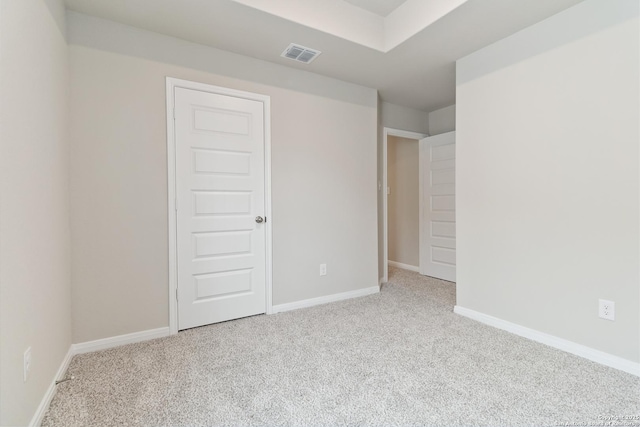 carpeted empty room featuring visible vents and baseboards