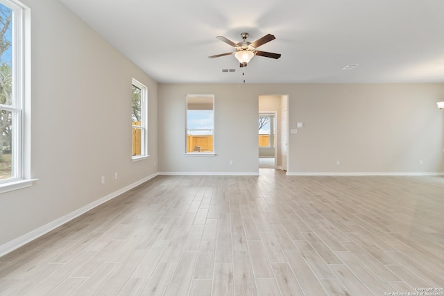 unfurnished room featuring light wood finished floors, ceiling fan, visible vents, and baseboards