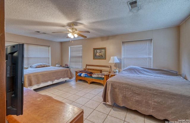 bedroom featuring visible vents, ceiling fan, a textured ceiling, and light tile patterned floors