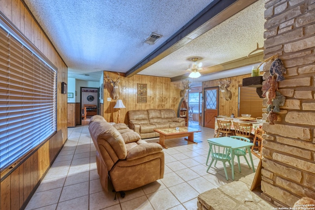 living area with a textured ceiling, light tile patterned floors, and visible vents