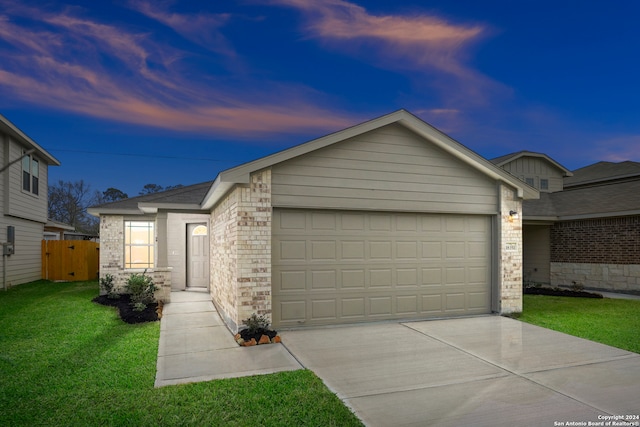 ranch-style house featuring a garage and a lawn