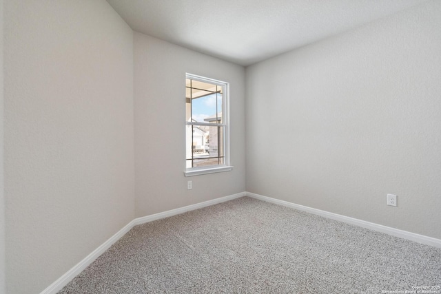 empty room featuring baseboards and carpet flooring