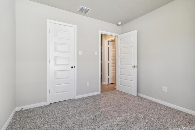 unfurnished bedroom featuring carpet, visible vents, and baseboards