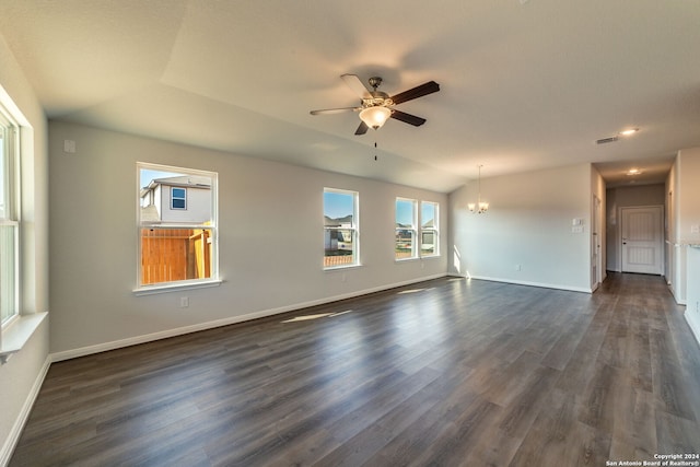 unfurnished room featuring ceiling fan with notable chandelier, dark wood-style flooring, vaulted ceiling, and baseboards