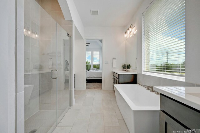 bathroom featuring tile patterned floors, independent shower and bath, and vanity